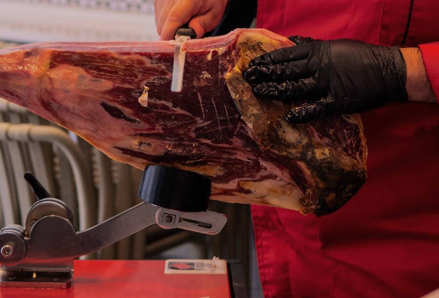 Pieza de jamón sobre la jamonera durante el corte